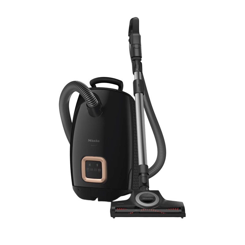 Black canister vacuum with a flexible hose and a telescoping wand, attached floor nozzle ready for cleaning safety hard floors and carpets.